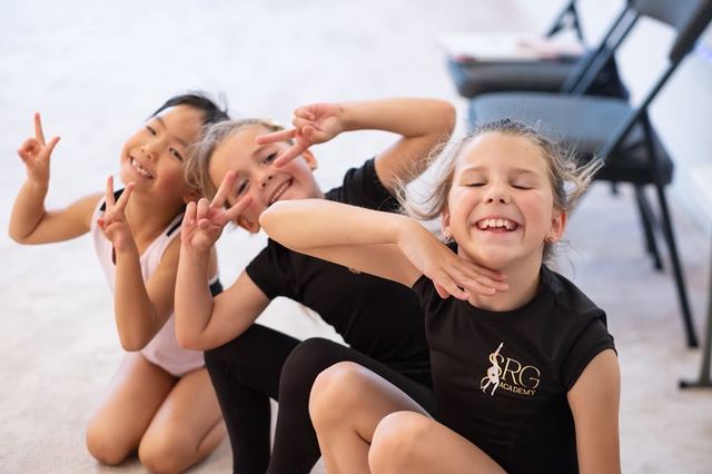 Young gymnasts laughing together during a class