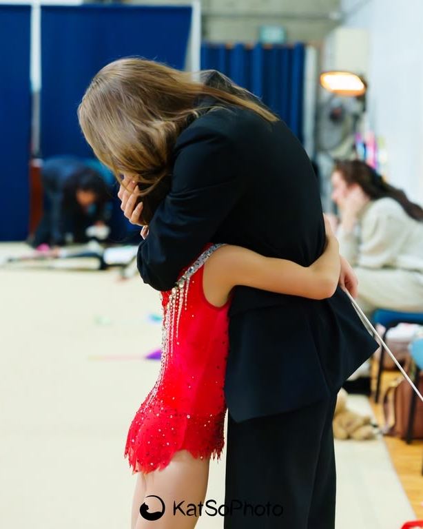 Coach Sofia hugging a gymnast straight after her competition routine