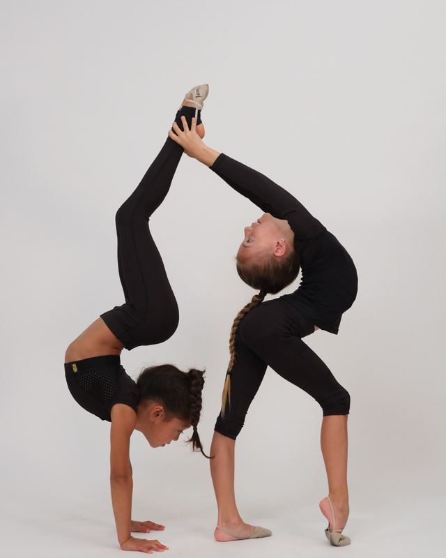 Gymnasts stretching together during a class