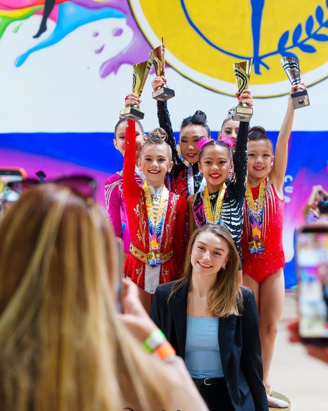 Gymnasts raising their medals on the podium