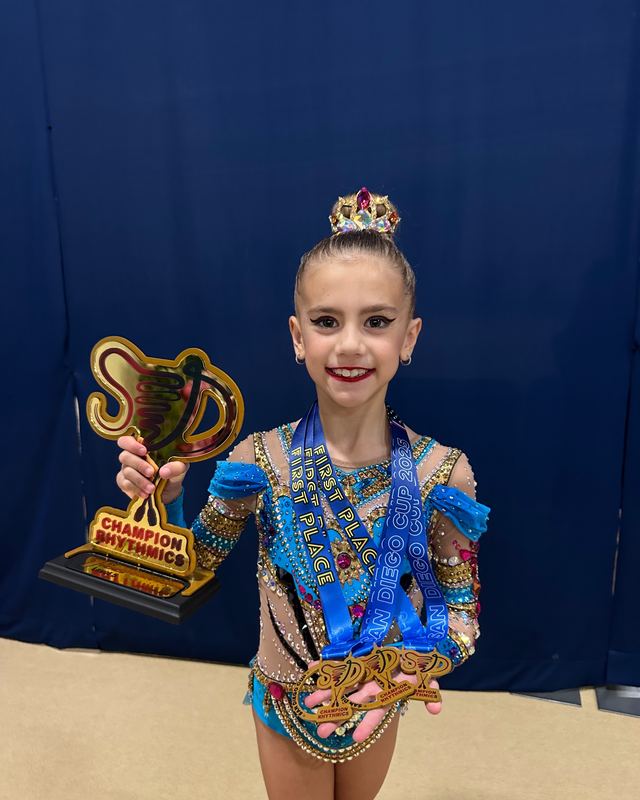 A gymnast holding a trophy after a competition