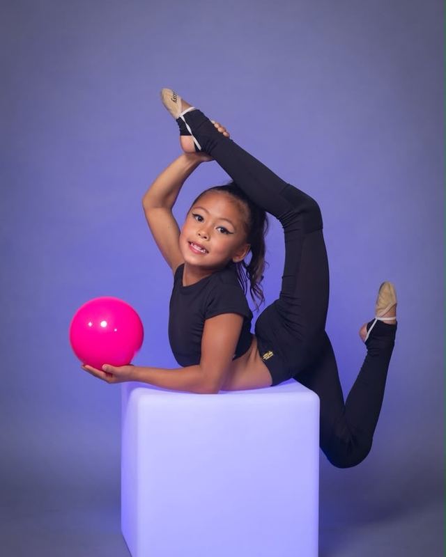A gymnast balancing with a ball